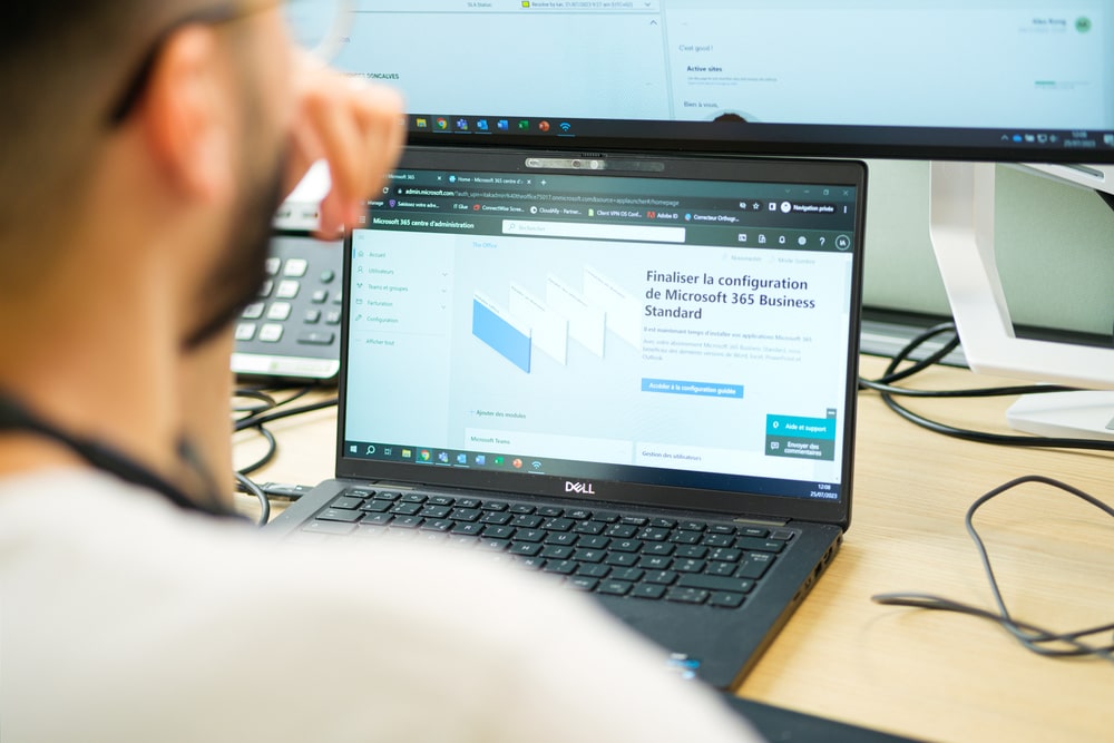 Technician setting up Microsoft 365 Business Standard on a Dell laptop
